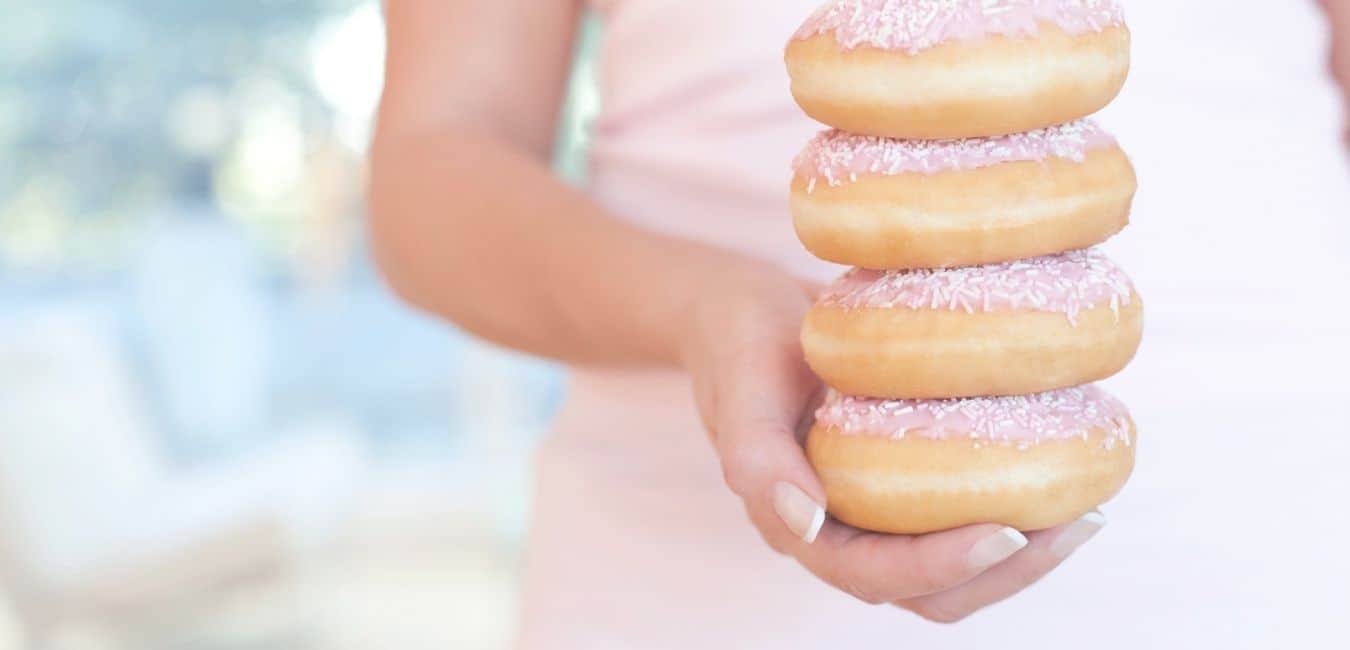 end overeating, woman holding 4 donuts