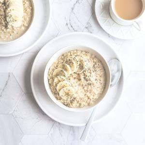 bowl of oatmeal with bananas, cashews, chia seeds, and cinnamon