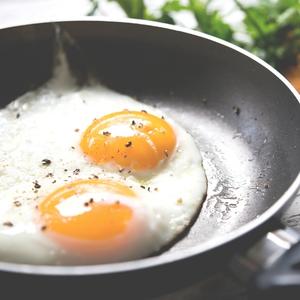 over easy eggs cooking in a skillet