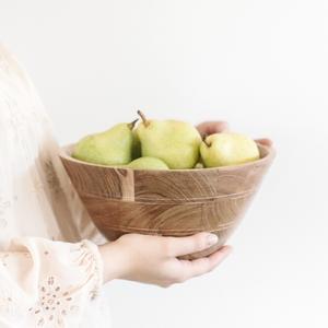 woman holding bowl of pears